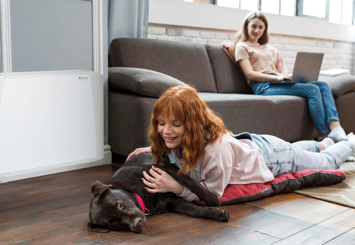 A girl and her dog next to a fan coil unit.