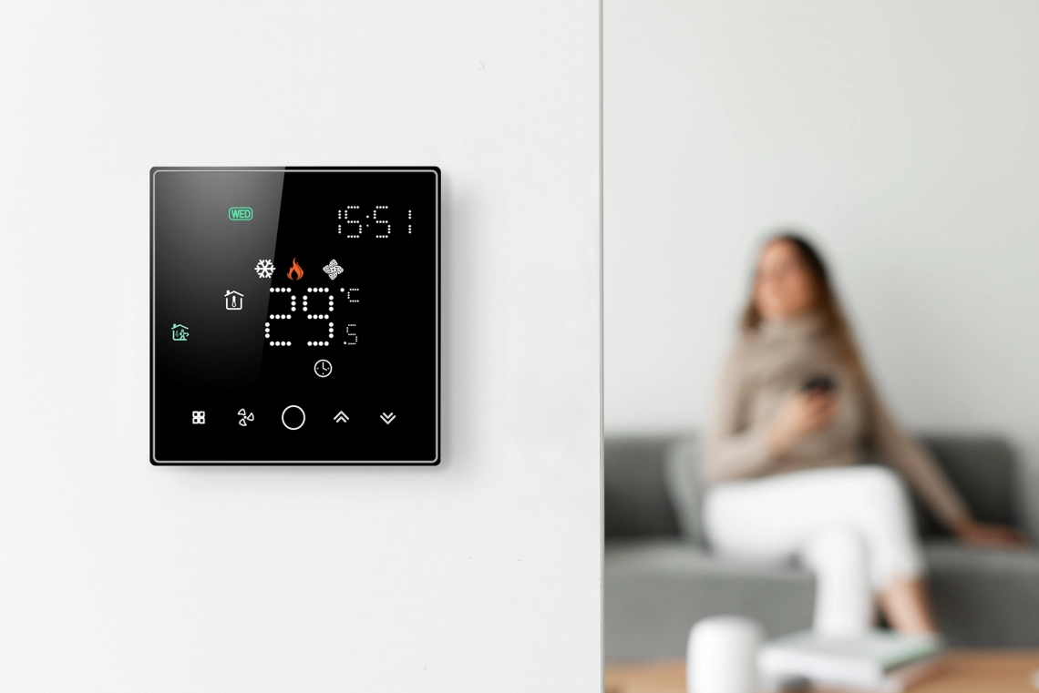 Fan coil thermostat display showing temperature settings.