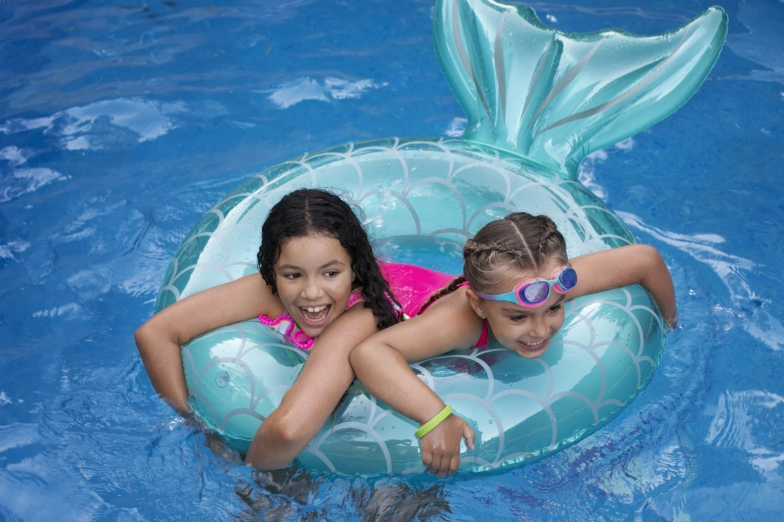 Children enjoying a swimming pool with bright floaters.