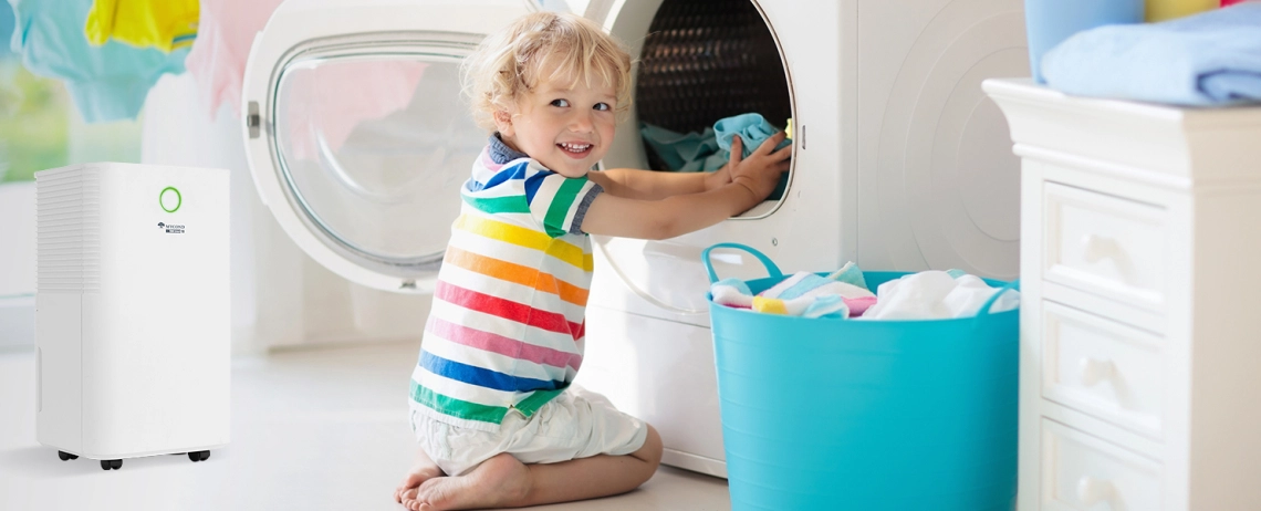 A young boy in a bathroom with a TIBO Smart 10 air dehumidifier, highlighting its child lock feature.